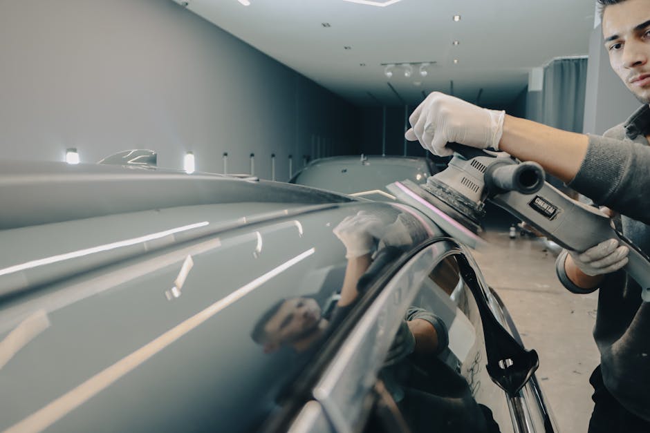 Professional auto detailer working on vehicle paint